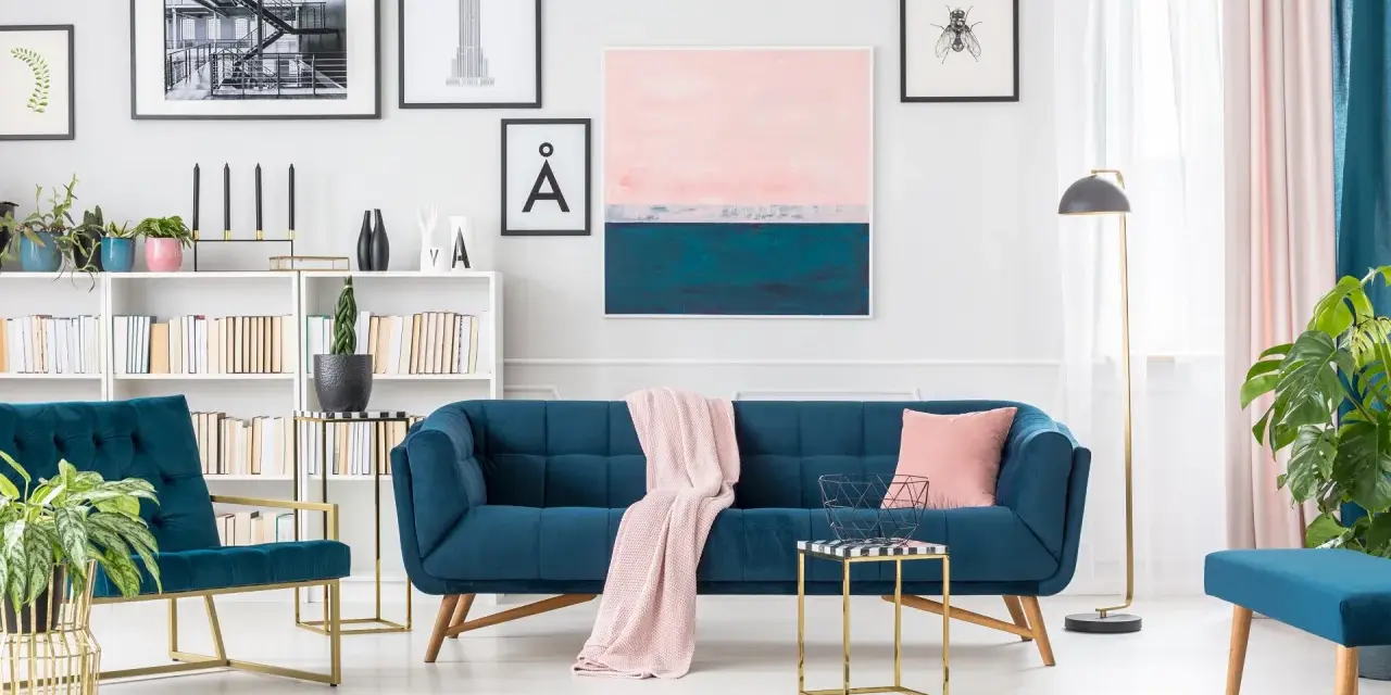 Granatowa sofa i fotele z pudrowym różem tworzą elegancką przestrzeń.