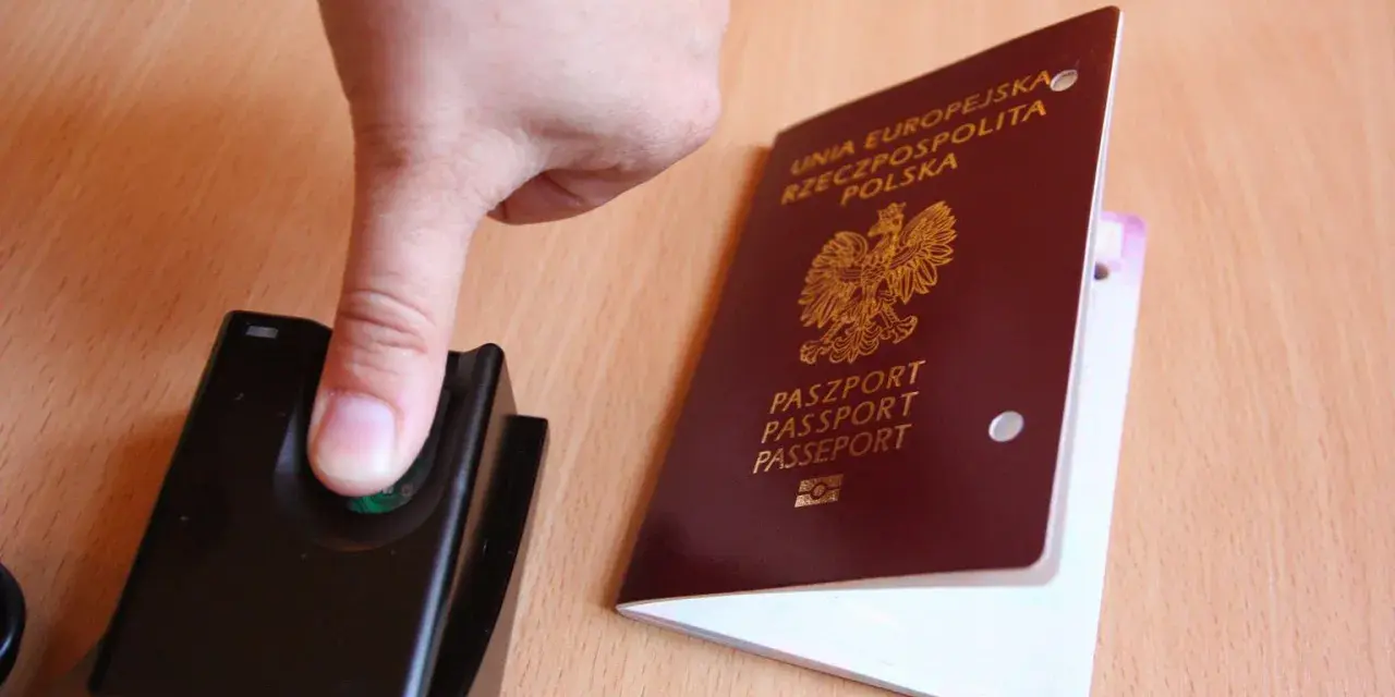 Palec na czytniku linii papilarnych obok polskiego paszportu. To pokazuje, ile ważny jest paszport w dzisiejszych czasach.