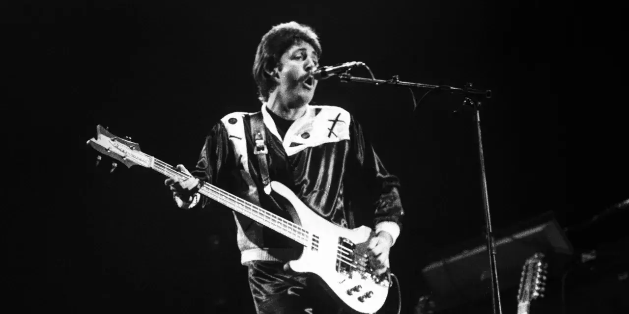Paul McCartney, jeden z legendarnych amerykańscy piosenkarze lat 80., gra na gitarze basowej podczas koncertu.