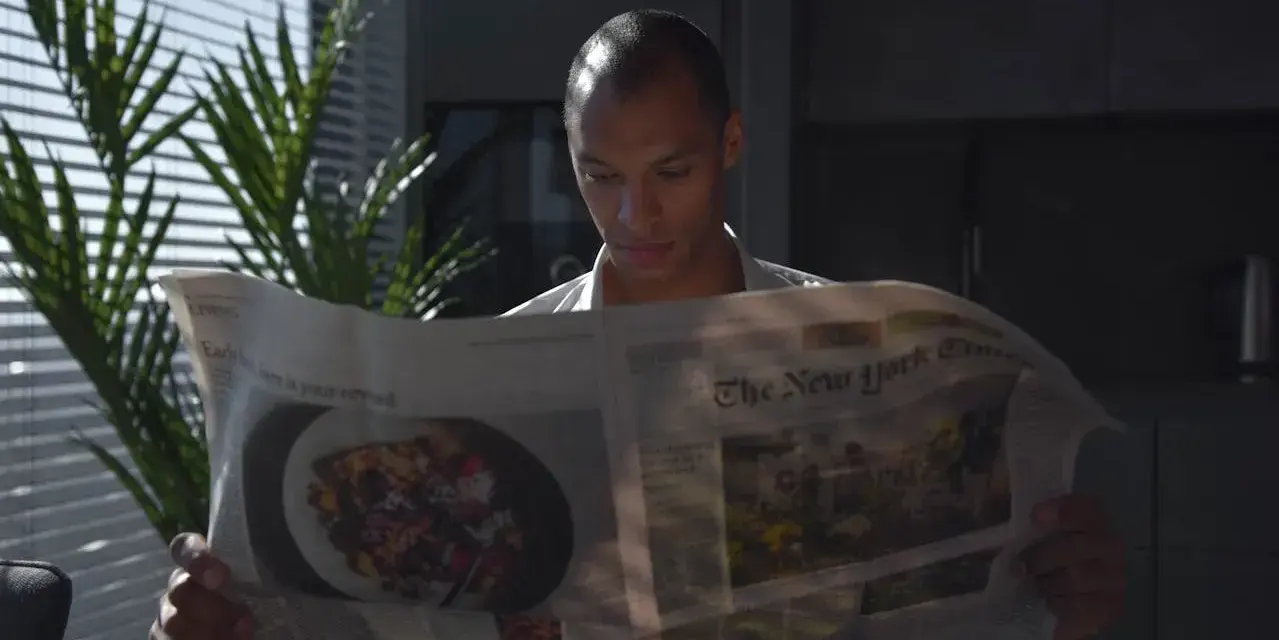 Mężczyzna czyta "The New York Times", zastanawiając się, czy urlop przechodzi do nowego pracodawcy.