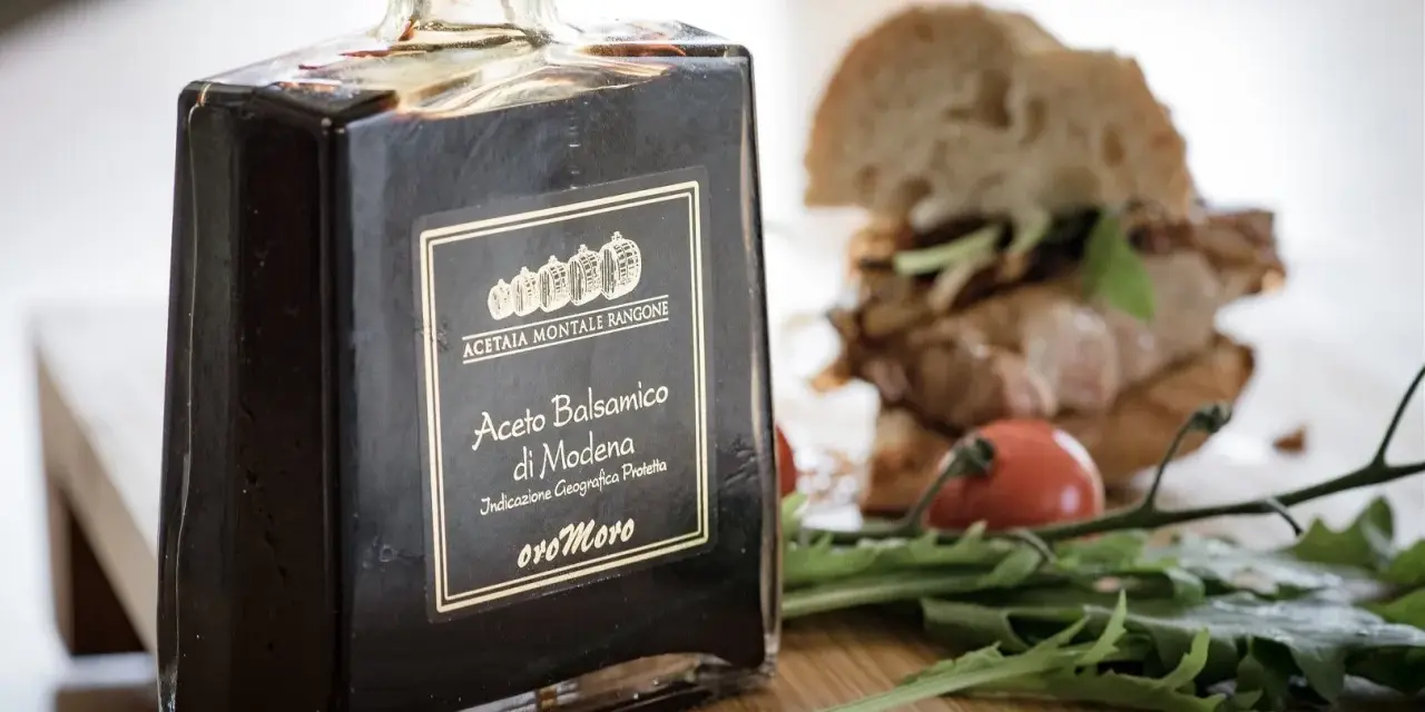 Butelka octu balsamicznego z Modeny obok kanapki i rukoli. Czy ocet balsamiczny jest zdrowy?