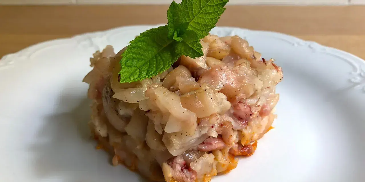 Deliciosa terrina de manitas de cerdo, con trozos tiernos y gelatinosos, coronada con una hoja de menta fresca.