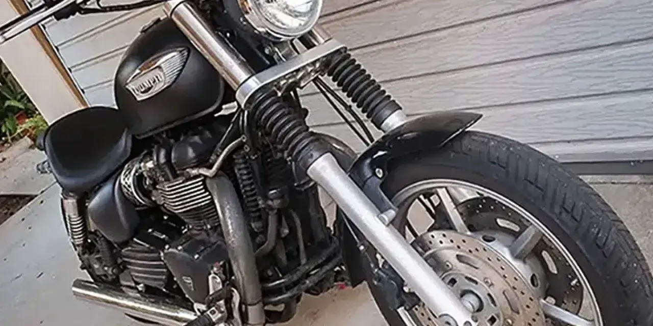 Czarny motocykl Triumph Speedmaster z chromowanymi elementami, gotowy na przygodę.