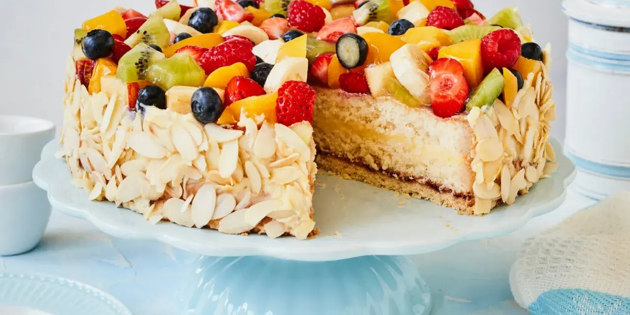 Ein bunter Obstkuchen, verziert mit Mandelsplittern, inspiriert zu neuen obstkuchen rezepten.