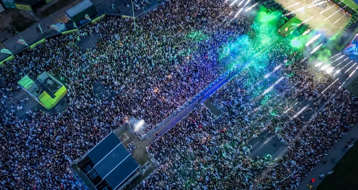 Tłum ludzi na koncercie podczas Łódź Summer Festival 2026. Kolorowe światła i dym tworzą niesamowitą atmosferę.