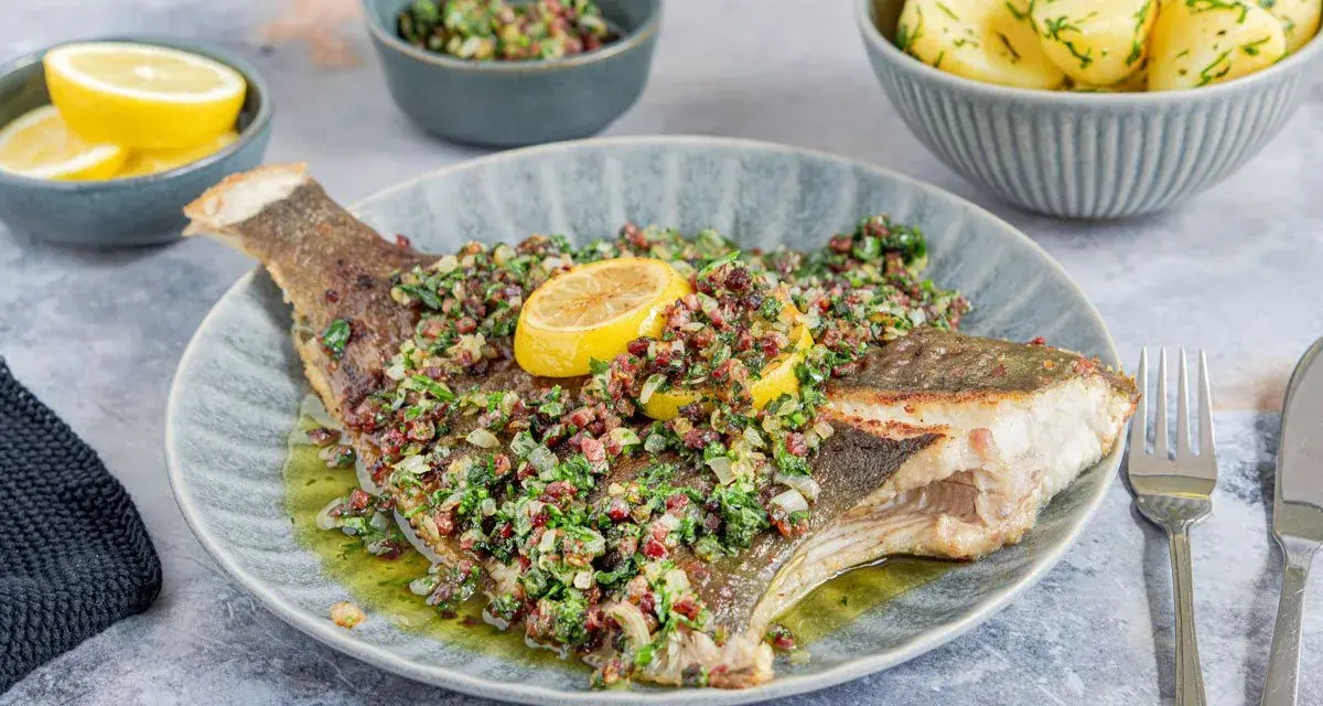 Gebratene Scholle mit Kräutern und Zitrone, serviert mit Salzkartoffeln. Ein köstlicher Fisch für Genießer.