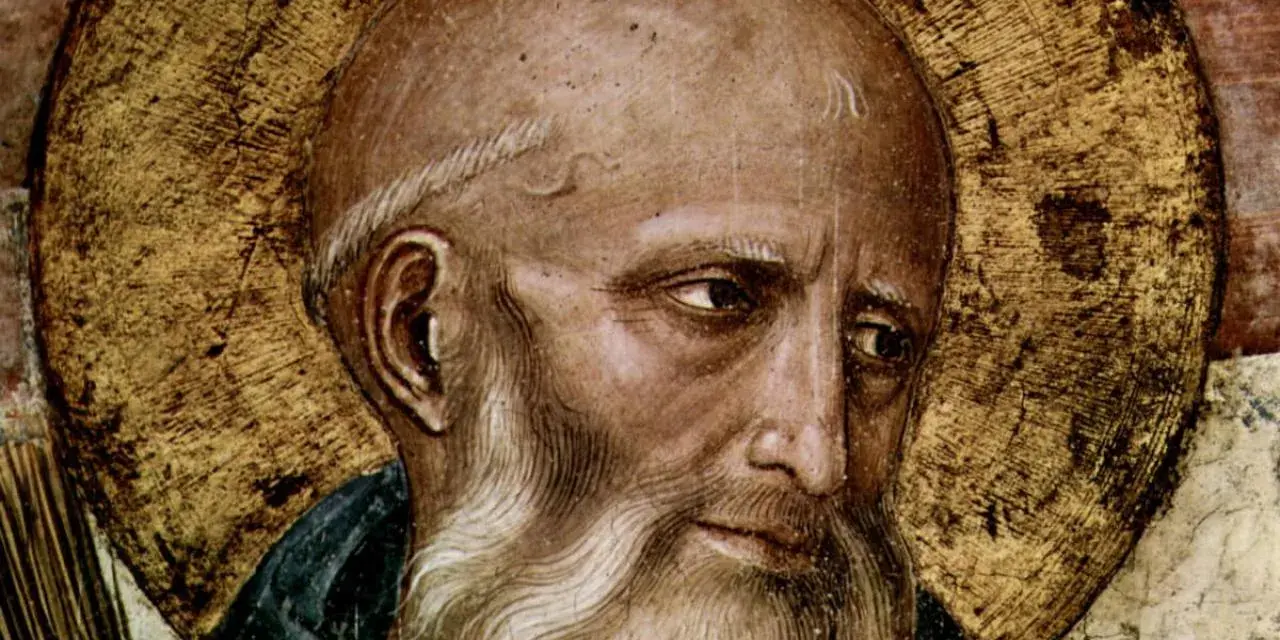 Close-up of a fresco depicting St. Benedict, with a golden halo and a wise, weathered face.