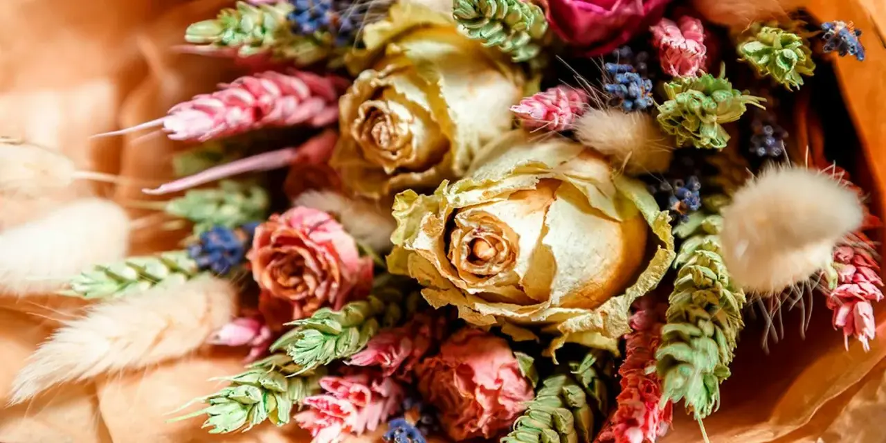 En vacker bukett med torkade blommor, som rosor och lavendel, visar hur torkar man blommor för att bevara deras skönhet.