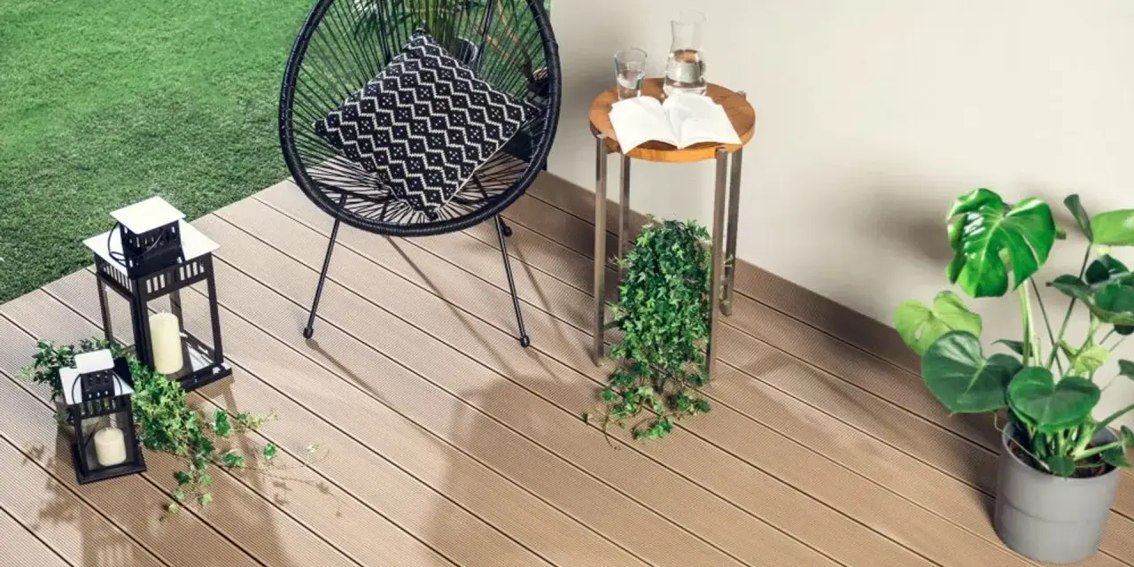 Nowoczesne deski kompozytowe to świetny pomysł, czym wyłożyć balkon. Wygodne krzesło, stolik i latarenki tworzą przytulną atmosferę.
