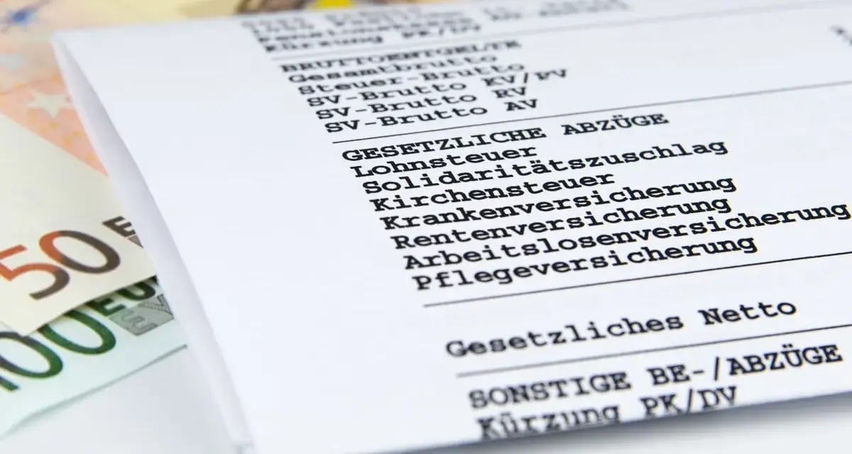 Ausschnitt einer Gehaltsabrechnung mit Posten wie Lohnsteuer, Kirchensteuer und Sozialabgaben. Daneben liegen Euro-Scheine.