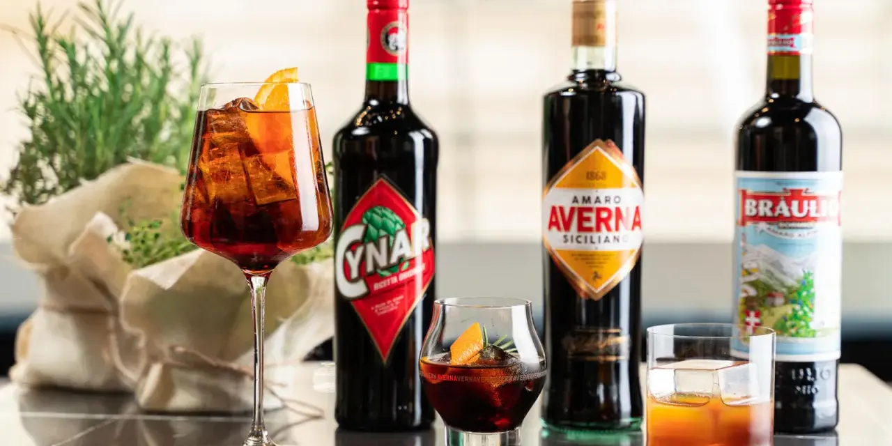 Verschiedene Campari-Sorten: Cynar, Averna und Braulio, serviert in Gläsern mit Eis und Orangenscheiben.
