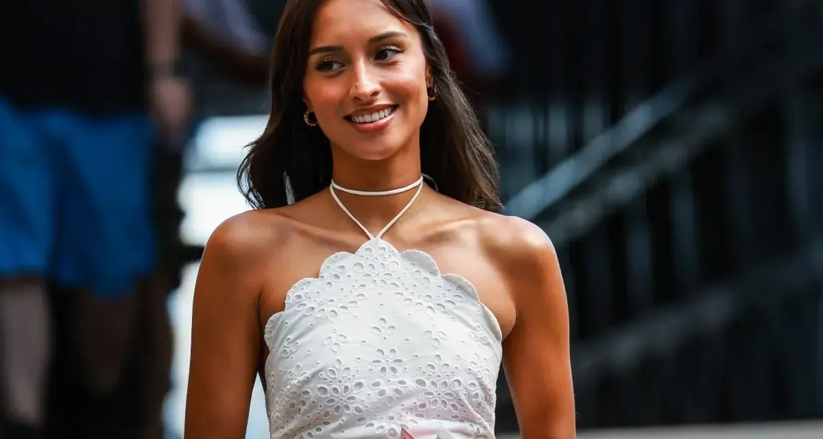 La presunta **Charles Leclerc fidanzata**, Charlotte Siné, sorride con un top bianco ricamato.