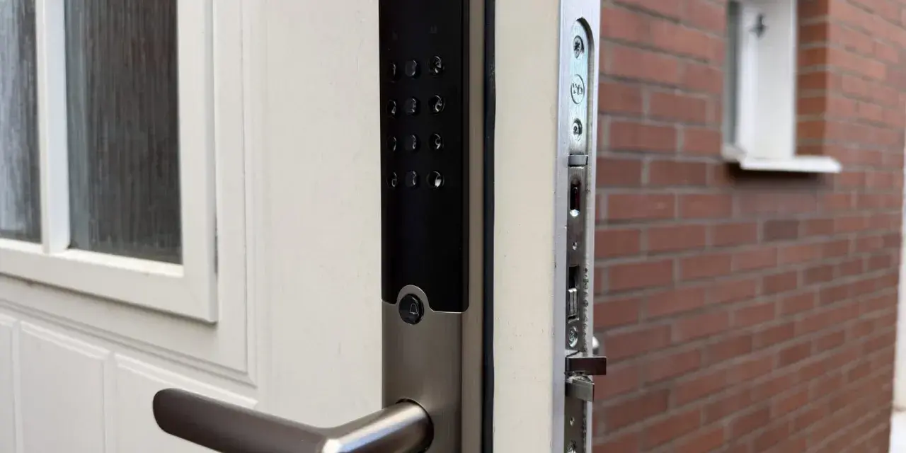 Yale Doorman, en smart lås som kan styras med Google Home, monterad på en vit dörr.