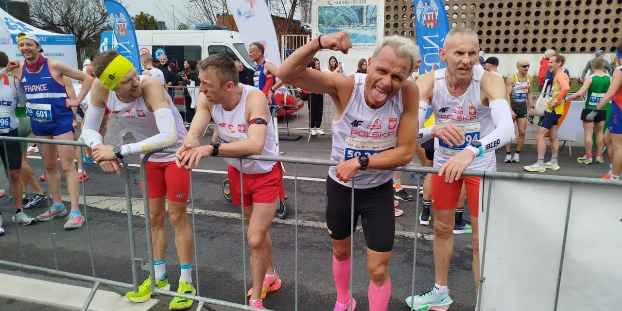 Marcin Konieczny i inni biegacze w biało-czerwonych strojach czekają na start.