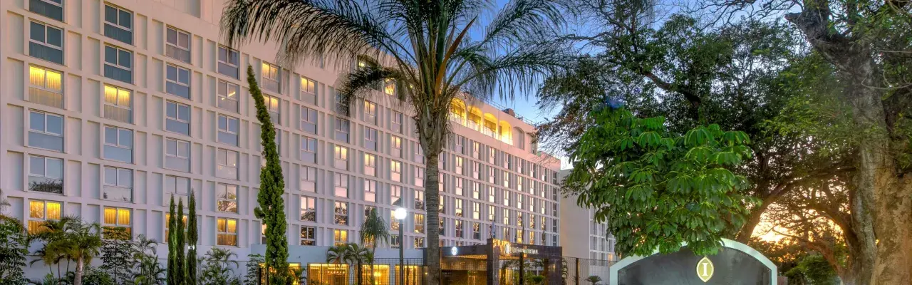 Elegancki hotel w Lusace, stolicy Zambii, otoczony bujną zielenią i palmami.