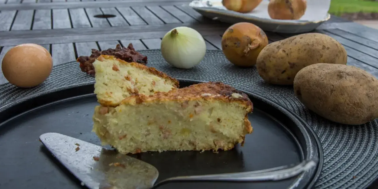 Babka ziemniaczana przepis babci: pyszne ciasto ziemniaczane z boczkiem, jajkiem i cebulą, składniki na stole.