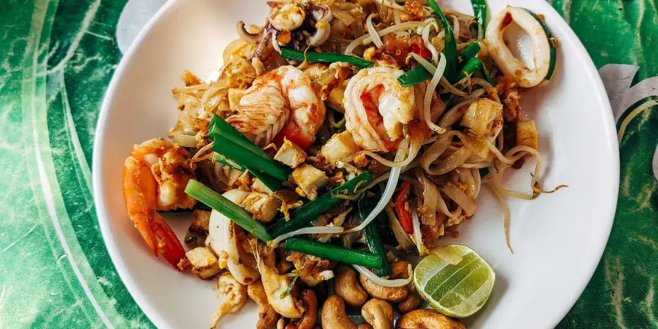 Talerz Pad Thai z krewetkami, kalmarami, orzechami i limonką.