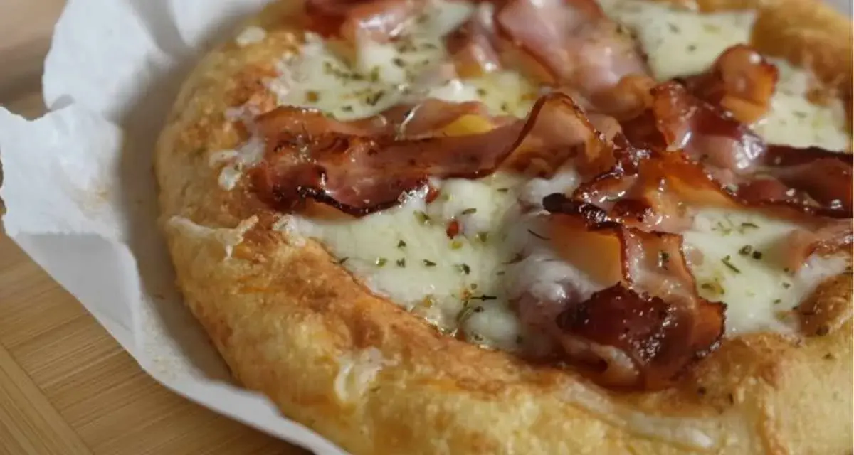 Pyszna pizza keto z chrupiącym boczkiem i ciągnącym serem, idealna na niskowęglowodanową ucztę.