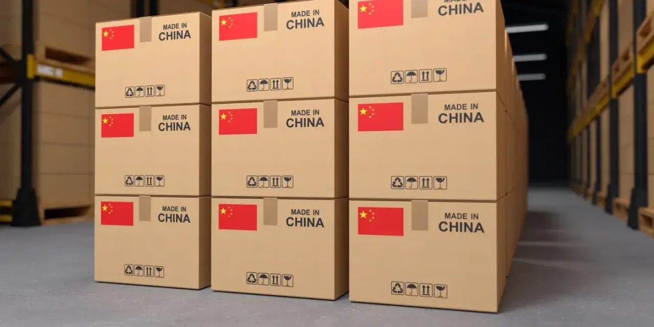 Pudełka z napisem "Made in China" i flagą Chin w magazynie. To przykład tego, co to jest import – towary produkowane za granicą.