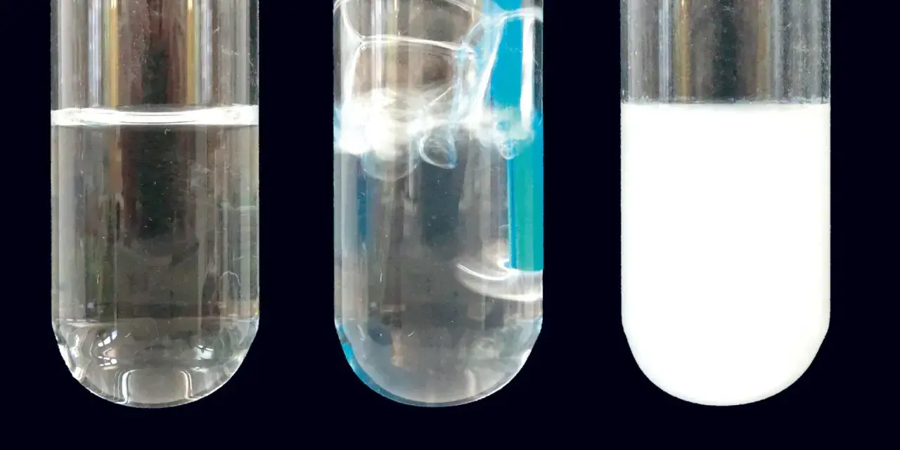 Drei Reagenzgläser zeigen eine klare Flüssigkeit, sprudelnde Flüssigkeit und eine milchige Flüssigkeit. Dies ist eine kalkwasserprobe.