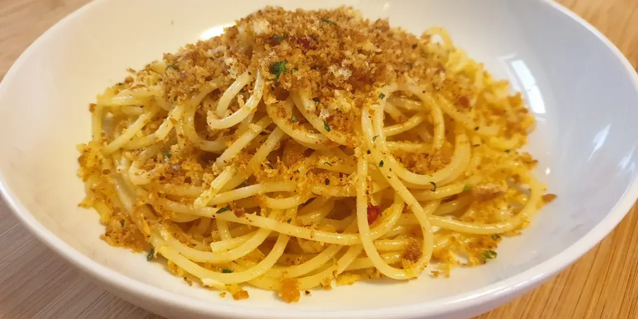 Spaghetti conditi con aglio, olio e abbondante pasta con la mollica croccante.