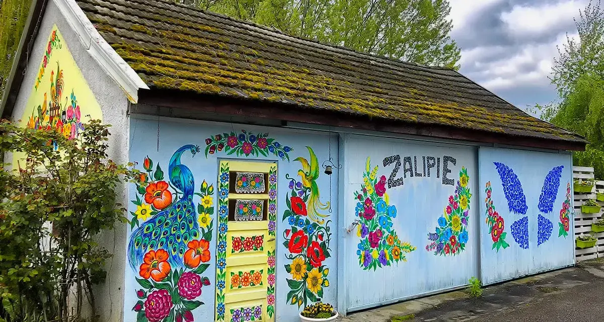 Kolorowy paw i kwiaty zdobią budynek w Zalipiu. Wspaniałe miejsce na zwiedzanie!