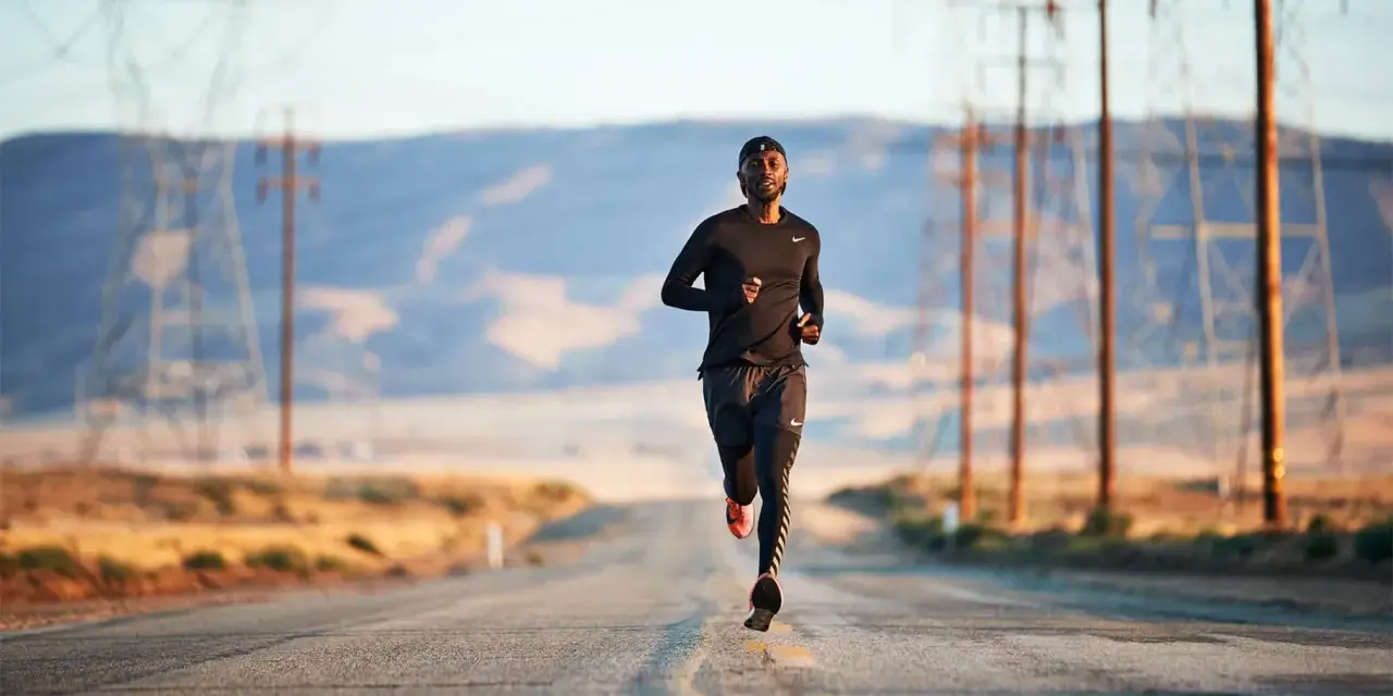 Un uomo corre su una strada deserta, circondato da tralicci dell'alta tensione. La corsa come fuga dalla depressione.