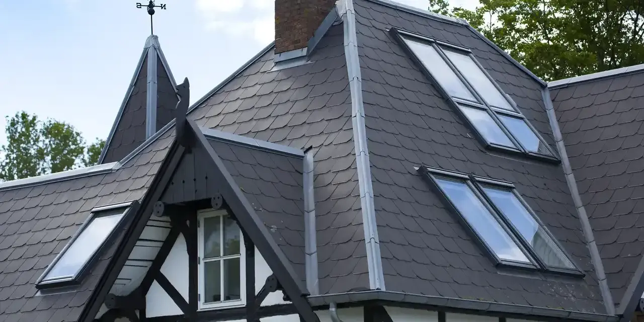 Tetti moderni con tegole scure e lucernari integrati, che valorizzano i materiali e l'architettura della casa.
