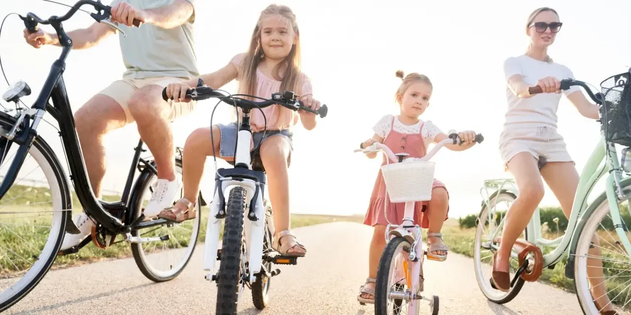 Rodzina na rowerach. Czy karta rowerowa jest obowiązkowa? Dzieci i rodzice cieszą się wspólną przejażdżką.