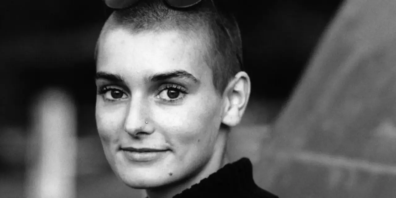Sinéad O'Connor mit Sonnenbrille auf dem Kopf, ein nachdenklicher Blick. Ihr ikonischer Titel "Nothing Compares 2 U" hallt nach.