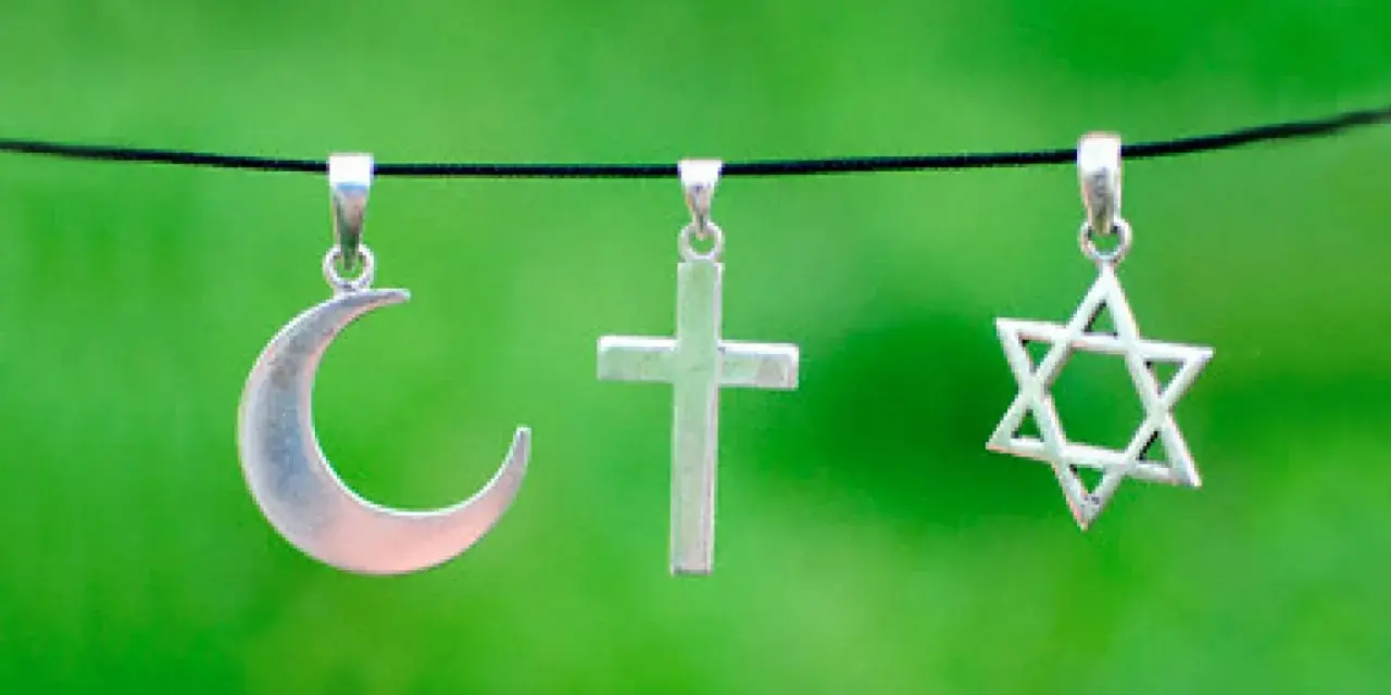 Srebrny półksiężyc, krzyż i gwiazda Dawida wiszą obok siebie. Symbolika islamu, chrześcijaństwa i judaizmu w harmonii.