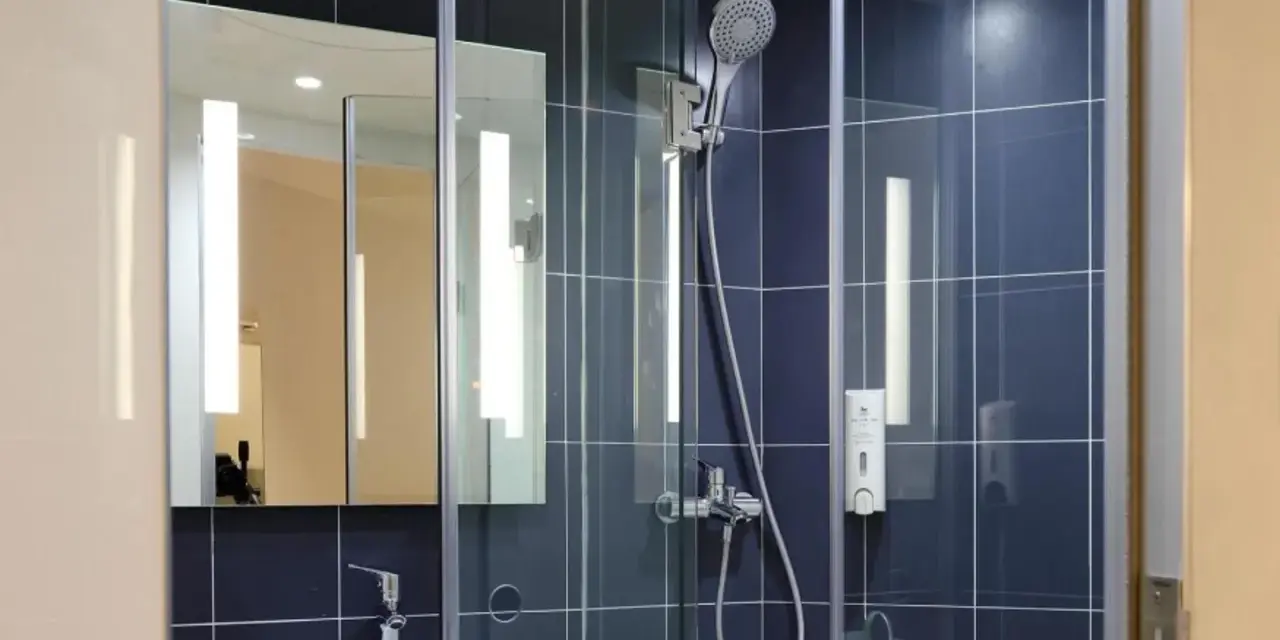 Doccia moderna con piastrelle blu. Valuta il costo sostituzione piatto e box doccia per un bagno rinnovato.