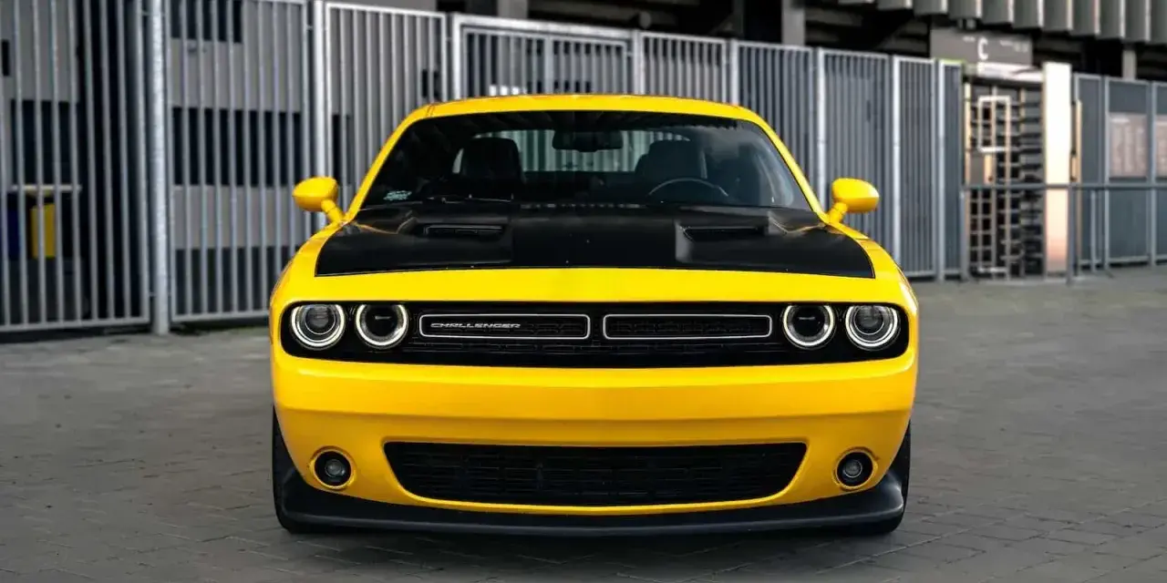 Żółty Dodge Challenger z czarną maską, gotowy do jazdy. Sprawdź jego atrakcyjną dodge challenger cena!