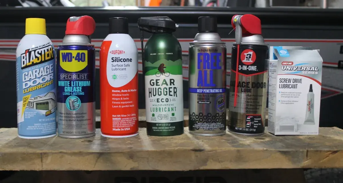 A collection of garage door lube and other lubricants, including Blaster, WD-40, Dupont Silicone, Gear Hugger, Free All, 3-in-One, and Genie Screw Drive Lubricant.