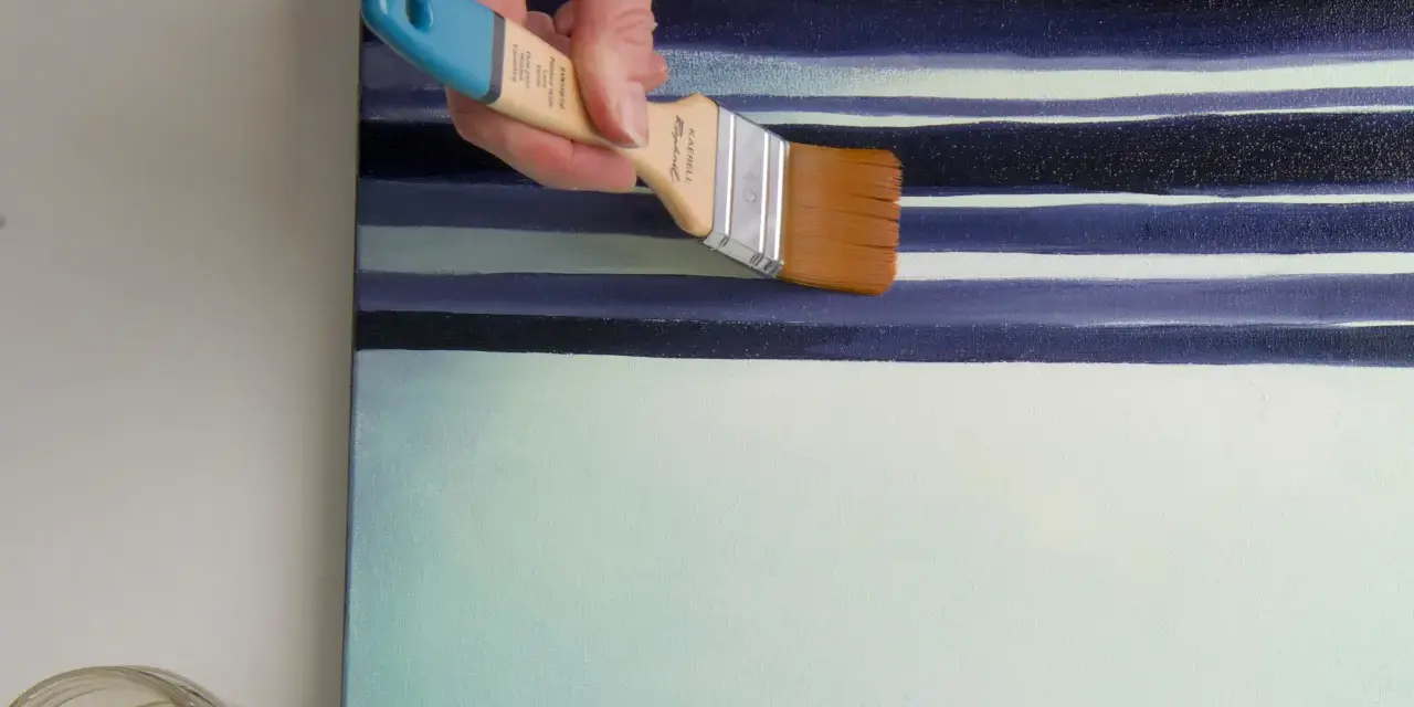 Main d'artiste appliquant une couche de vernis sur une toile aux rayures bleues et blanches. Quel vernis !
