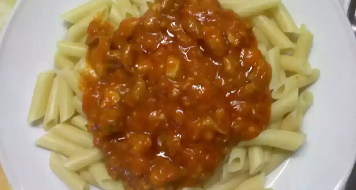 Macarrones con pollo en salsa roja, un plato casero listo para disfrutar.