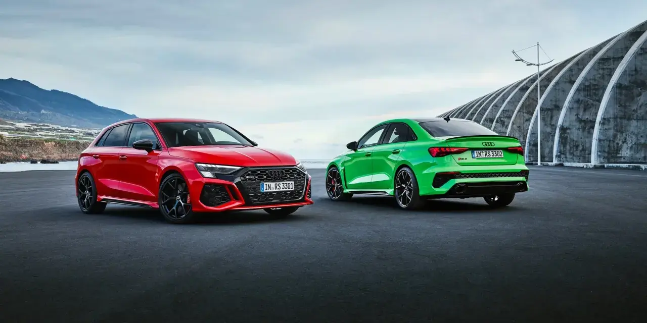 Dwa Audi RS3, czerwone i zielone, gotowe do sprintu 0-100 km/h.