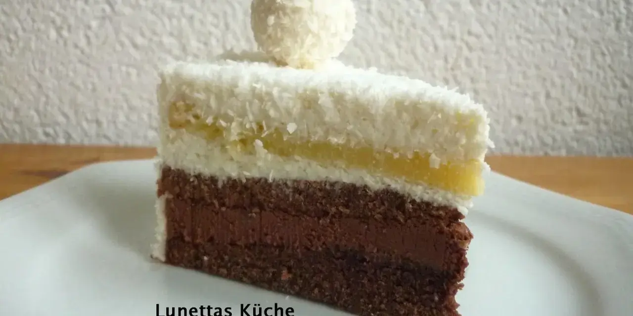 Ein Stück Schoko Kokos Torte mit Kokosraspeln und einer Praline obendrauf.