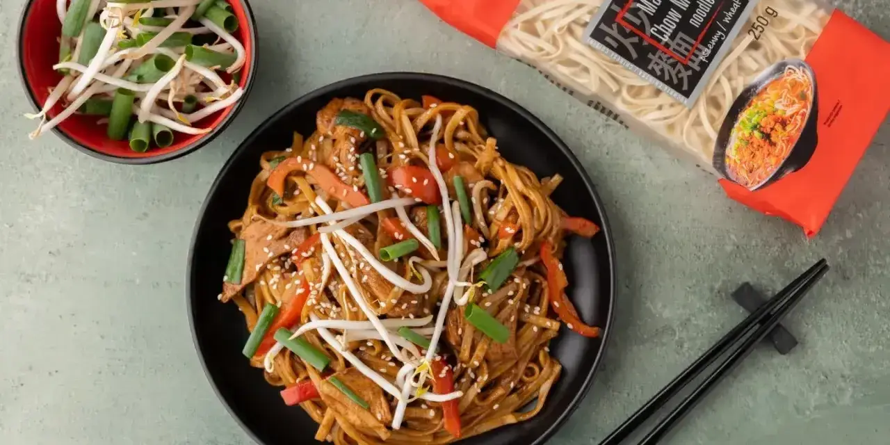 Gotowy **Chow Mein przepis** na talerzu: makaron z warzywami i kiełkami fasoli, obok paczka makaronu i miseczka kiełków.