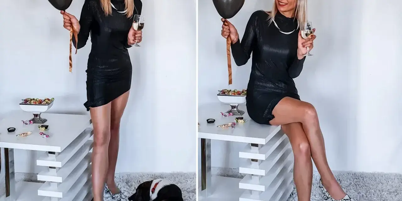 Elegancka czarna sukienka, idealna na 18. urodziny. W dłoni czarny balon i kieliszek szampana. Na podłodze leży piesek.
