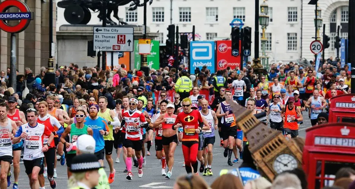 Corredores participan en el maratón de Londres, con Big Ben y cabinas telefónicas rojas de fondo.