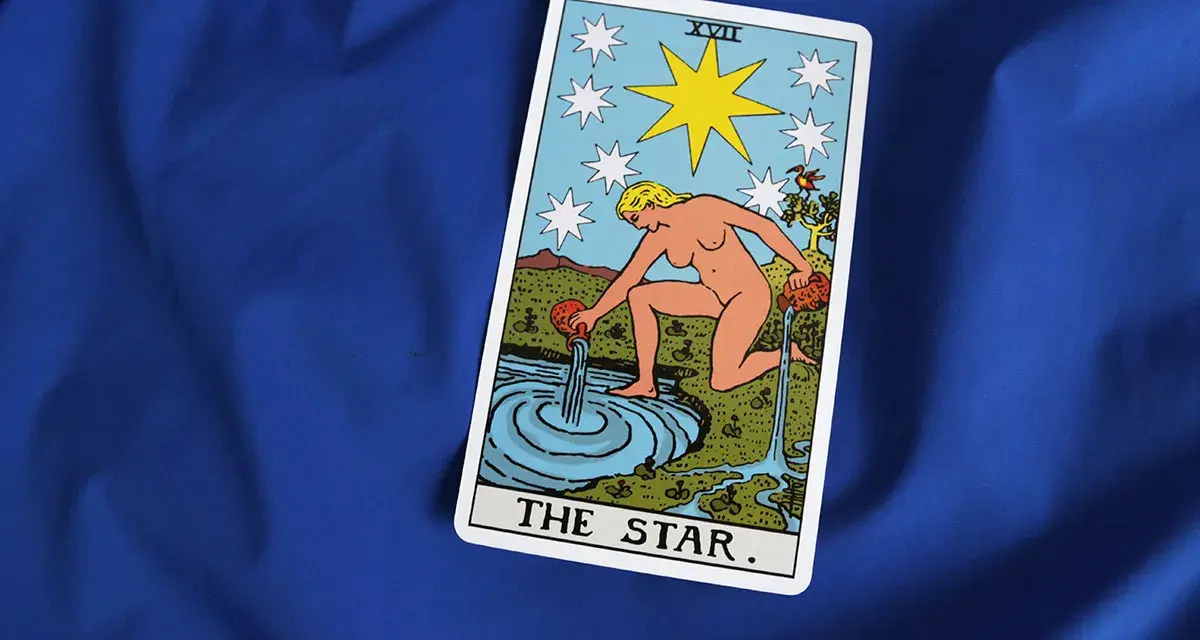 Karta XVII - Gwiazda Tarot. Kobieta wylewa wodę z dzbanów do stawu, symbolizując nadzieję i odnowę.