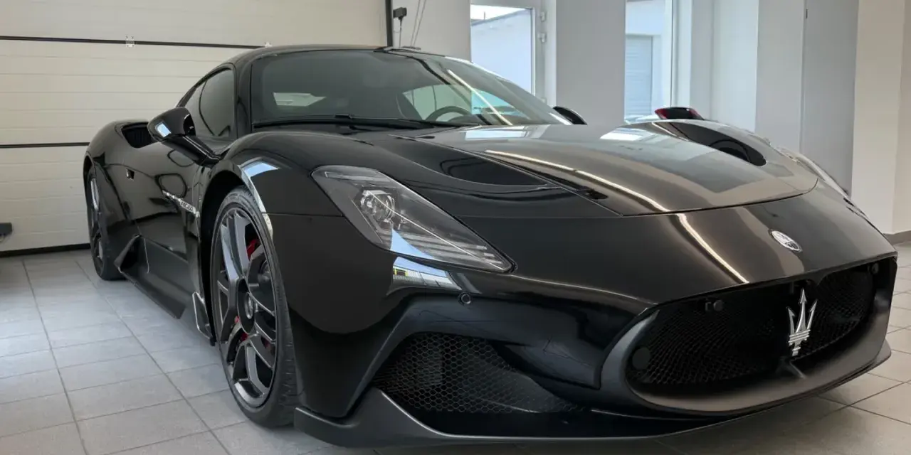Czarny Maserati MC20 w garażu, widok z przodu.