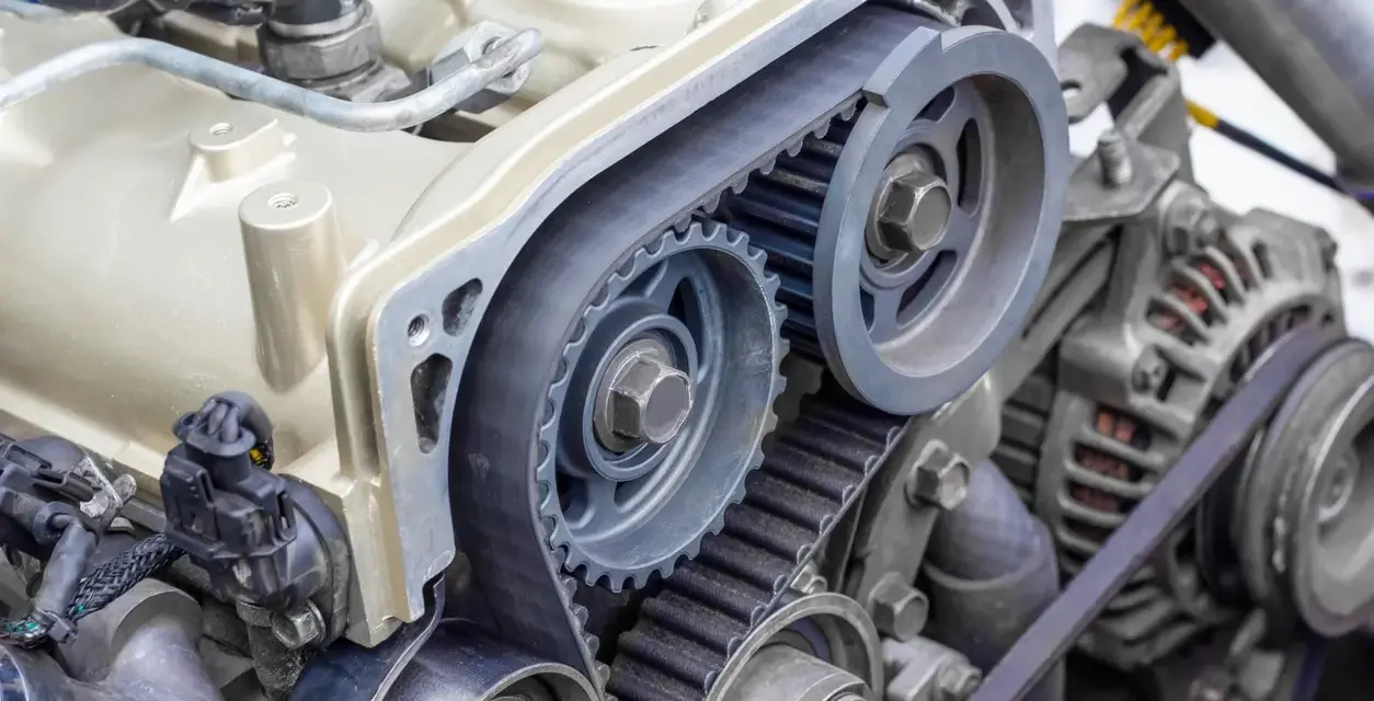 Close-up of a car timing belt system with gears and pulleys. This essential component ensures precise engine timing.