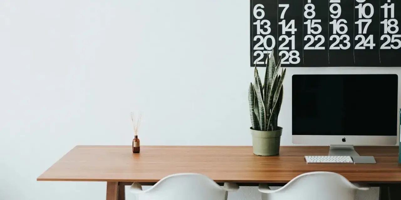 Escritorio moderno con ordenador, planta y calendario. Ideal para organizar tus aplicaciones de escritorio en la nube.