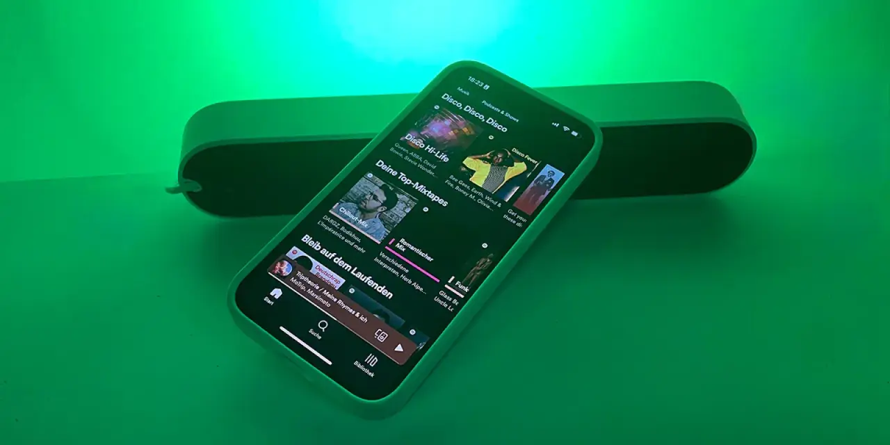 iPhone mit Spotify-App, das Disco-Musik abspielt, beleuchtet von Philips Hue Licht.