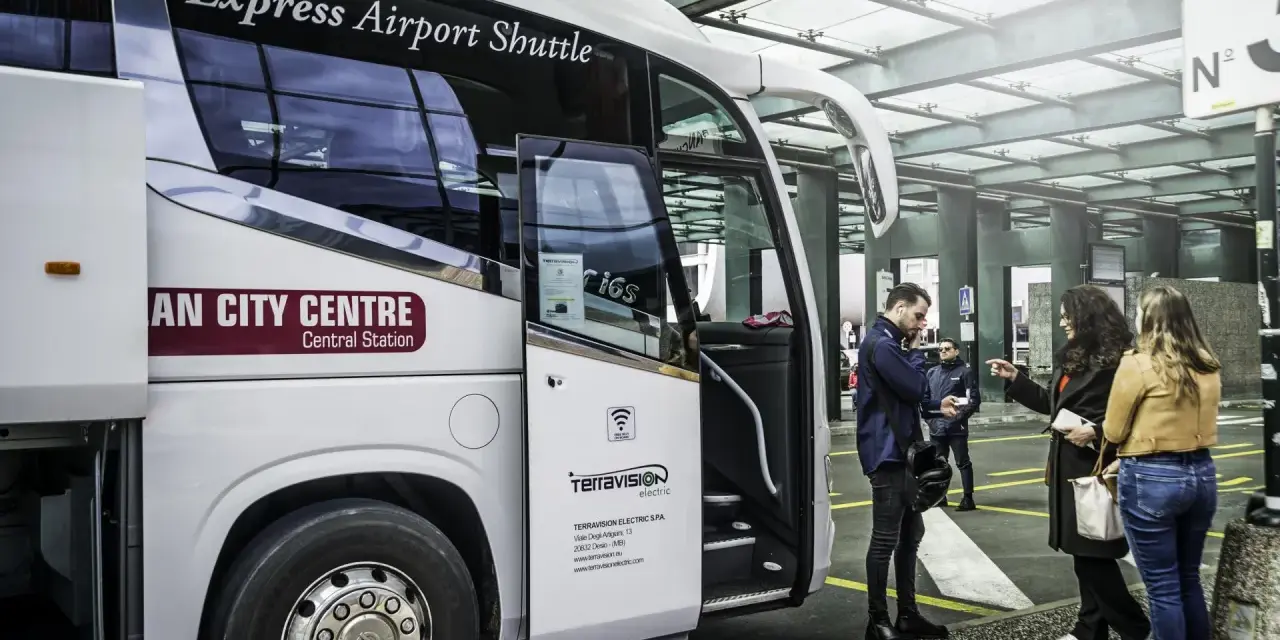 Autobus Express Airport Shuttle z napisem "AN CITY CENTRE Central Station" czeka na pasażerów. Podróż z Mediolan Malpensa do centrum jest prosta.