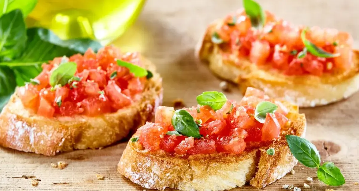 Bruschetta z pomidorami i mozzarellą – pyszny przepis na letnią przekąskę. Chrupiące grzanki z soczystymi pomidorami i świeżą bazylią.