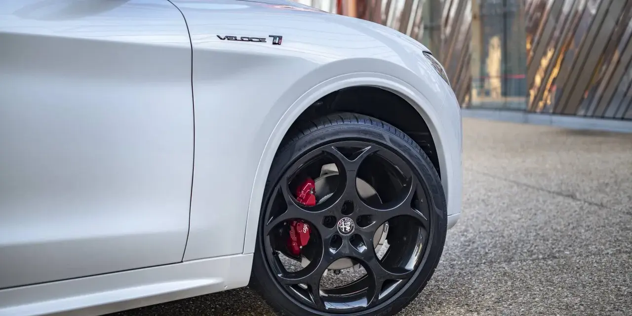 Dettaglio di un'auto bianca con cerchi Stelvio 21 originali e pinze freno rosse.