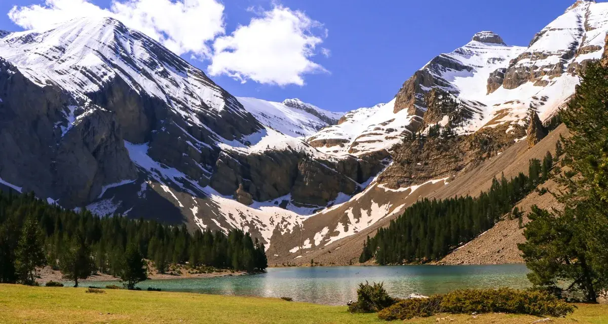 Majestuoso ibón de Plan, rodeado de montañas nevadas y bosques. Un paisaje perfecto para una ruta circular.